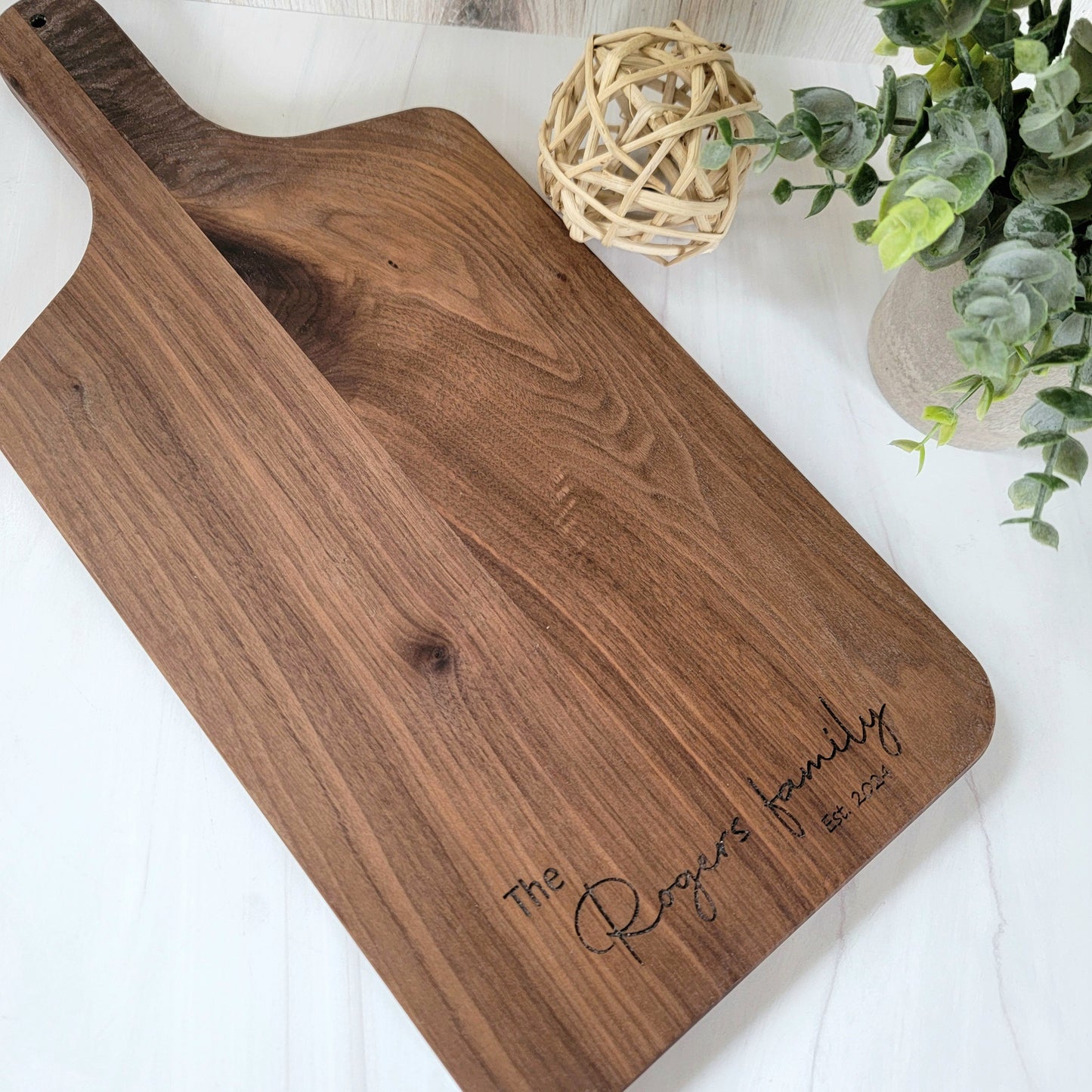 Elegant walnut cutting board with rich wood grain, showcasing a smooth surface and rounded edges. Size is 17 X 8.75. You have 6 available options to choose from for engraving. 